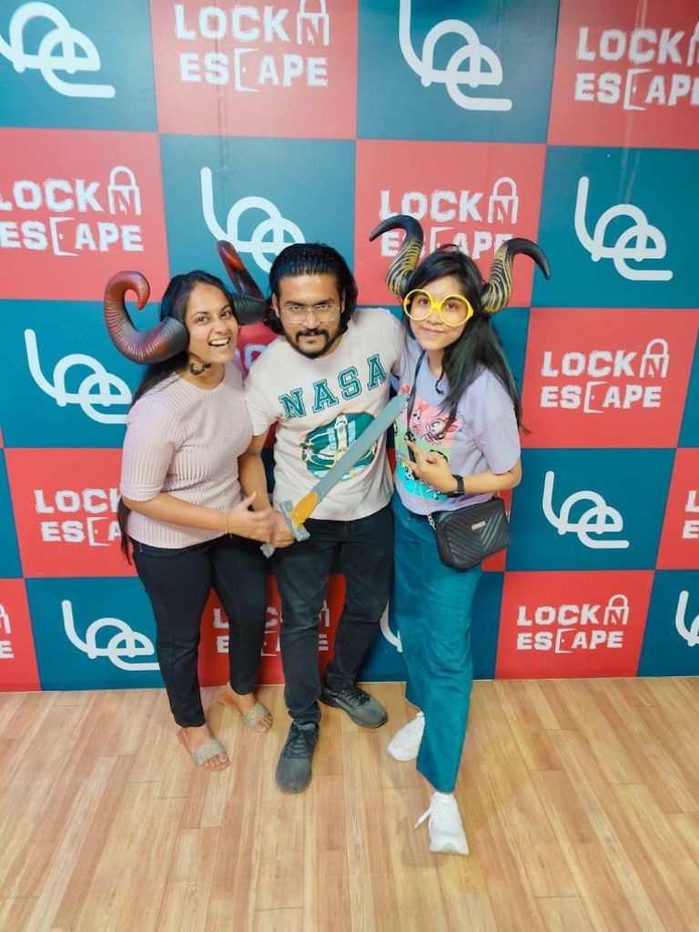 Friends posing with props after completing an escape room at LockNEscape in Hyderabad