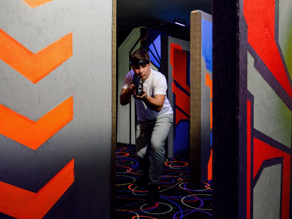 Player crouching with blaster inside SHOTT laser tag arena in Hyderabad