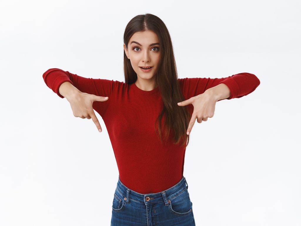 Woman in a red top pointing downwards, highlighting a call-to-action section