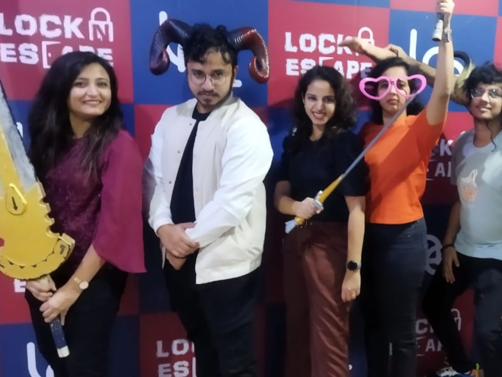 Group of players posing with fun props at Lock N Escape Hyderabad after completing an escape room