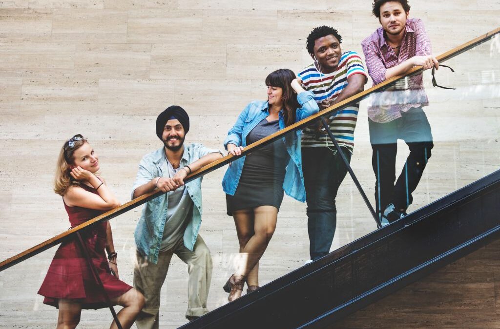 Diverse group of colleagues posing together on a staircase, representing the best corporate team outing places in Hyderabad for company outings and team building