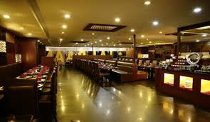A restaurant dining room with booth seating and a lit buffet counter